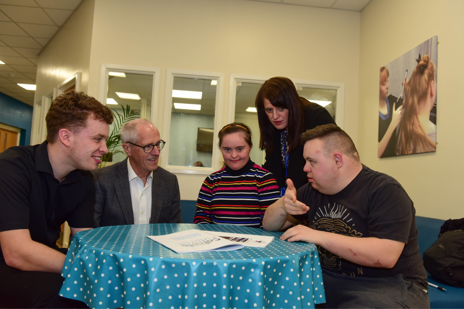 Sir John Holman sitting talking to students and staff at Catcote Academy in Hartlepool