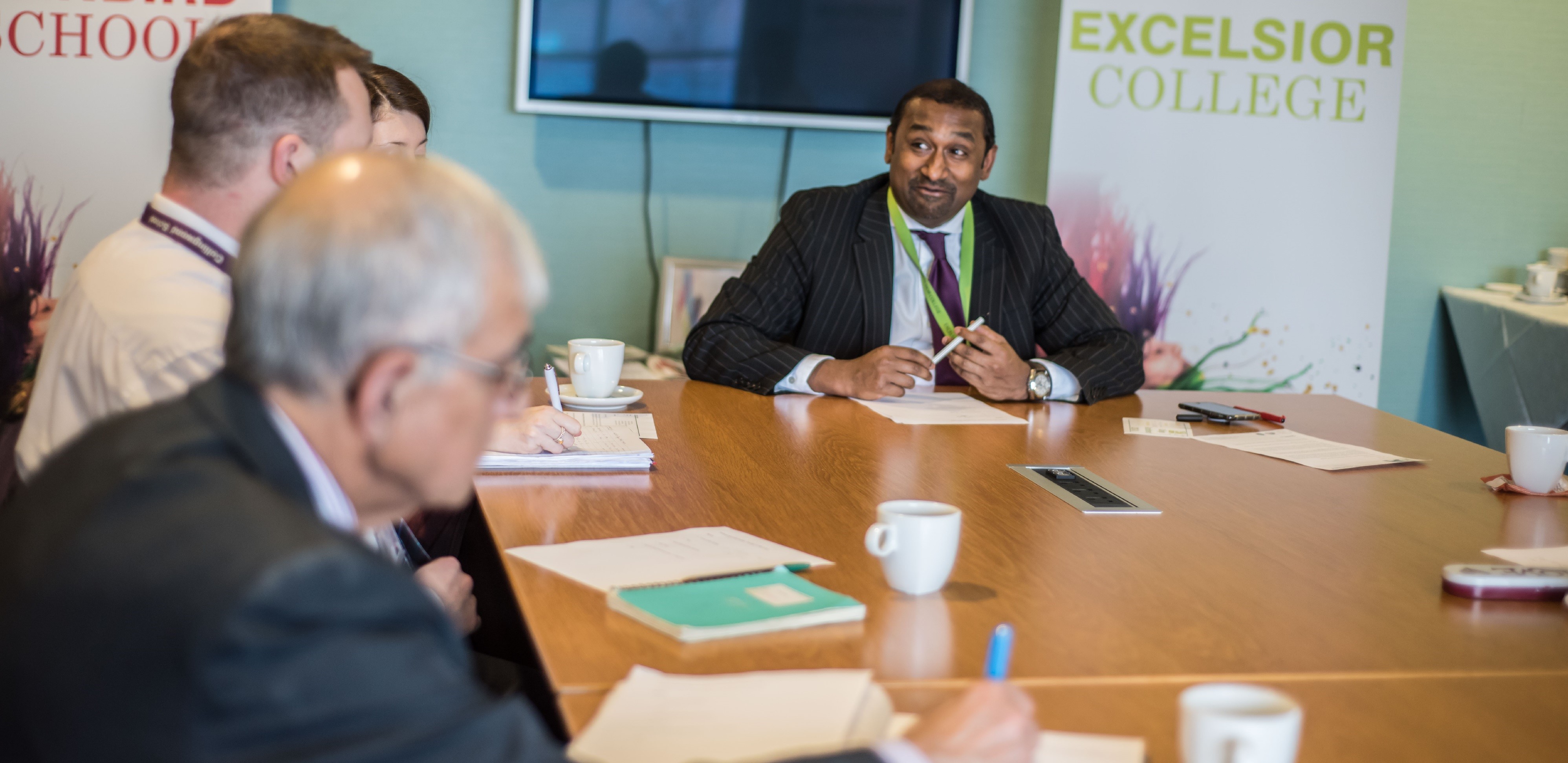 A headteacher sat around a table with staff