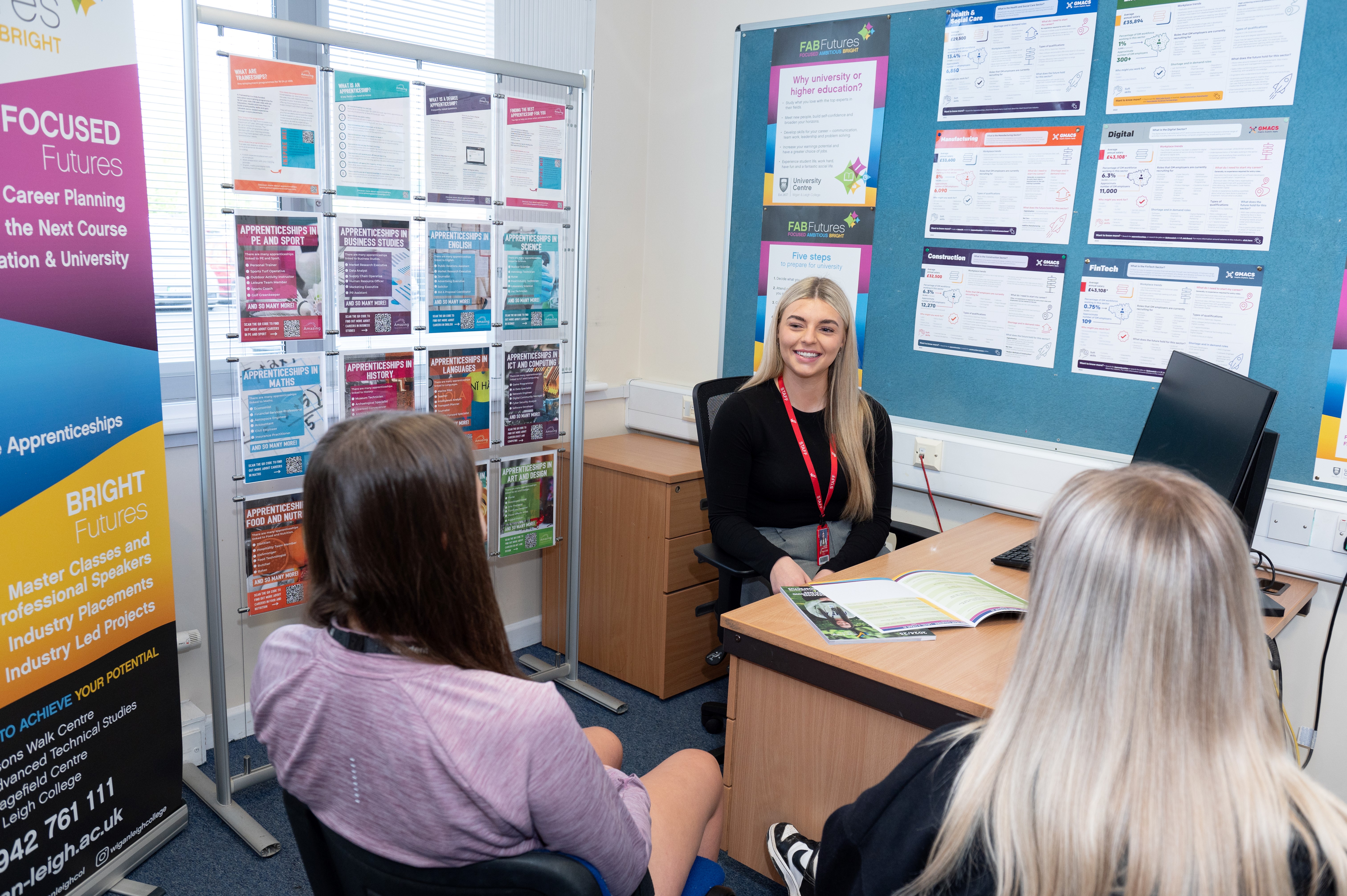 College students visiting a member of the careers team at Wigan & Leigh College.