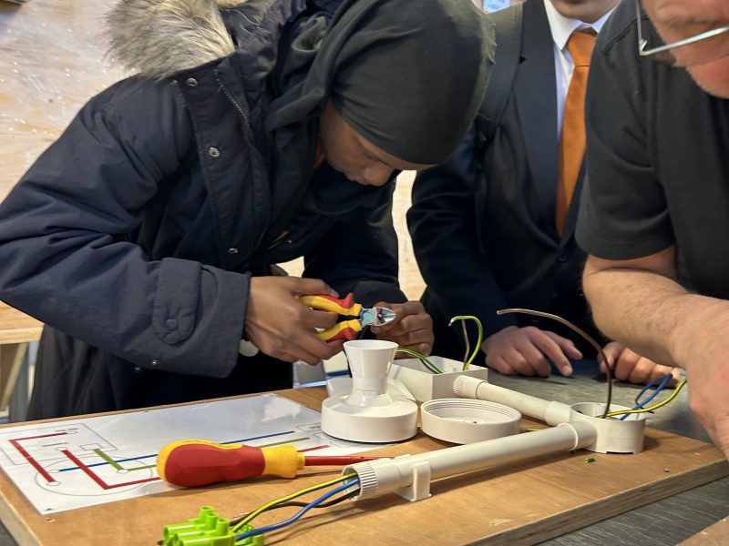 A student from Co-op Academy Leeds taking part in an employer-supervised electronics activity at a workbench