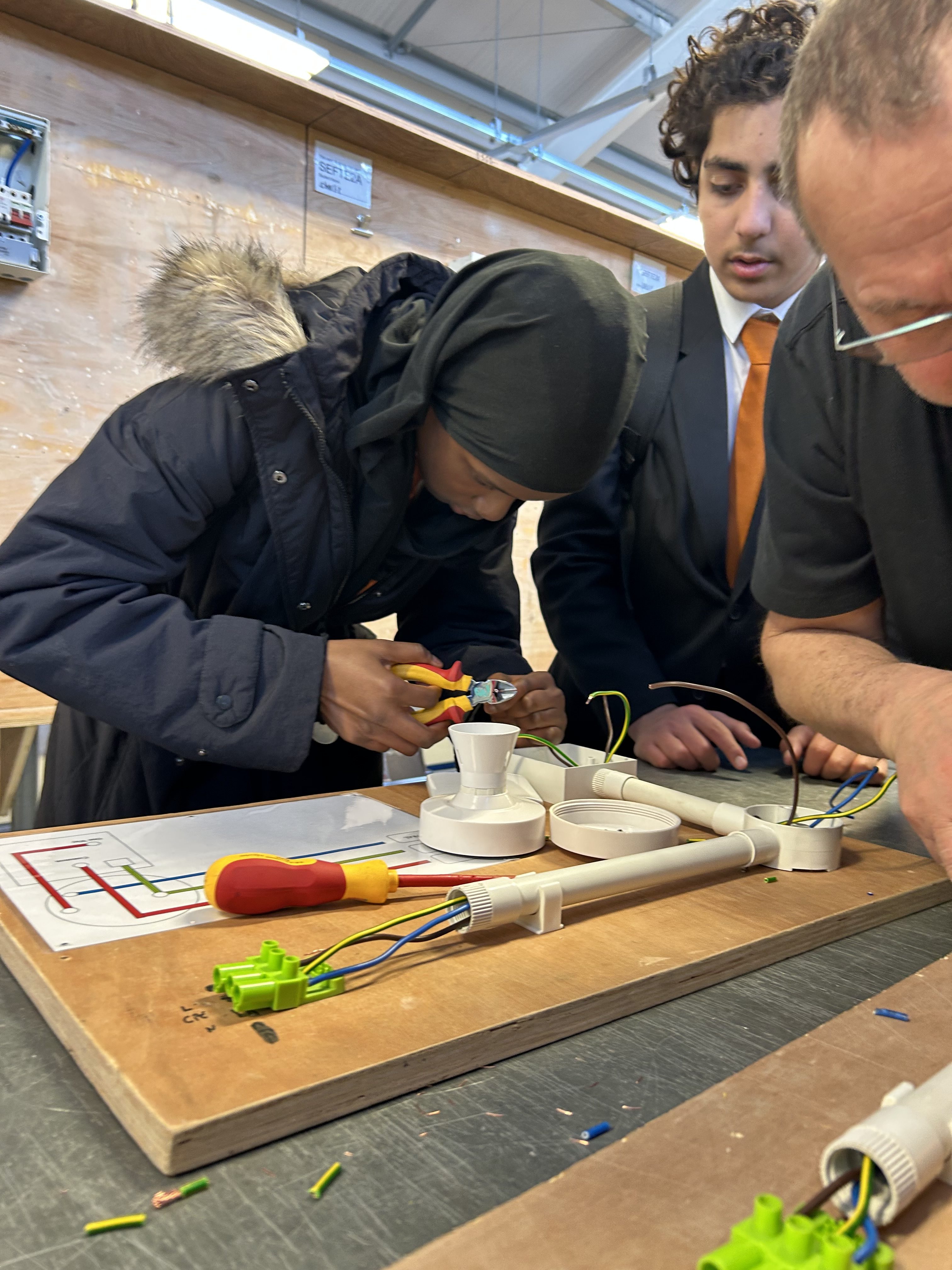 A student from Co-op Academy Leeds taking part in an employer-supervised electronics activity at a workbench
