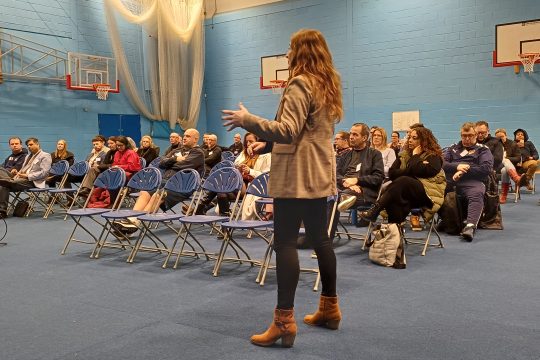 A Duston School member of staff presenting to teachers and employer representatives in a school hall