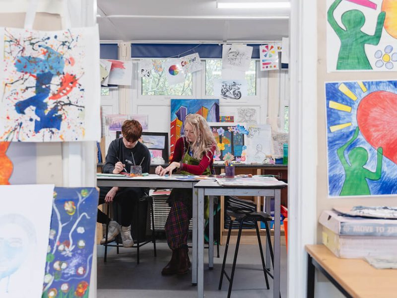 A teacher and pupil working together in a classroom