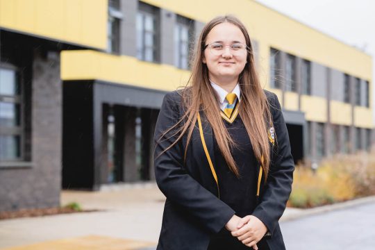 Kelsey smiling outside school