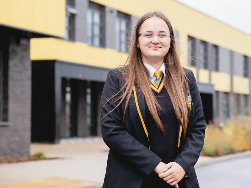 Kelsey smiling outside school
